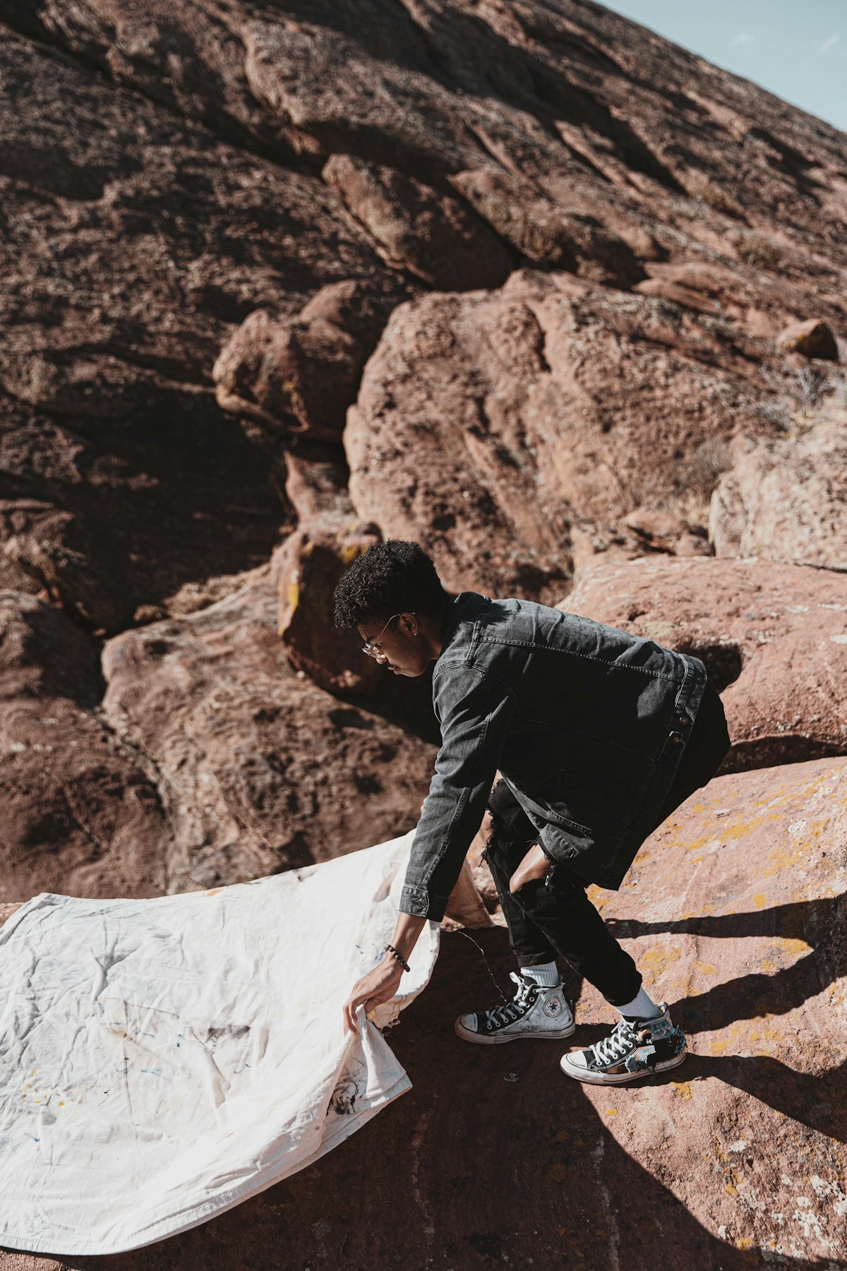 man in black jacket climbing on brown rock formation during daytime