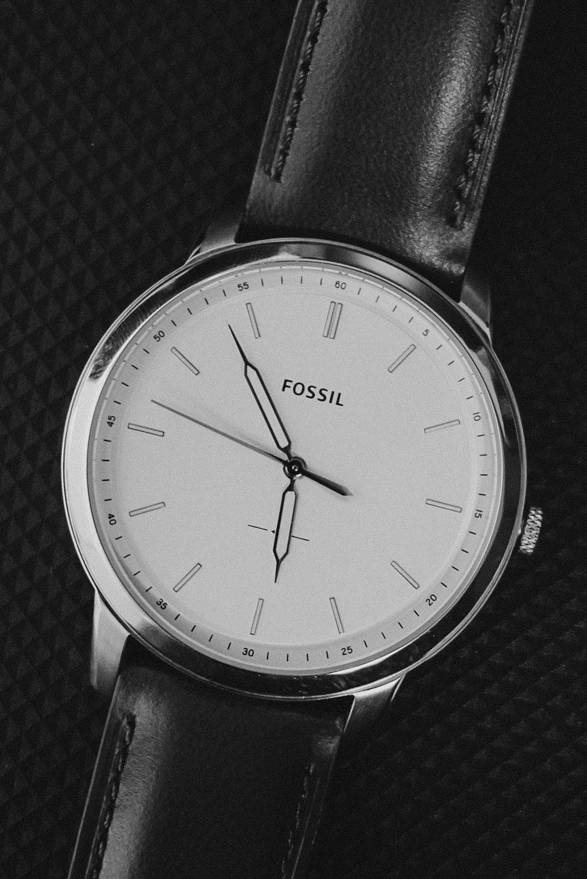 Fossil wristwatch with a white face and leather strap