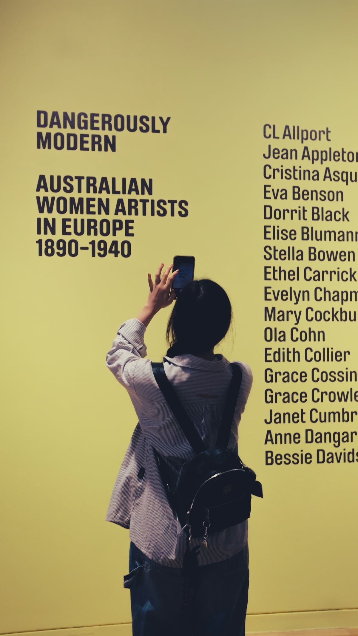 Woman photographs exhibition text about australian women artists.