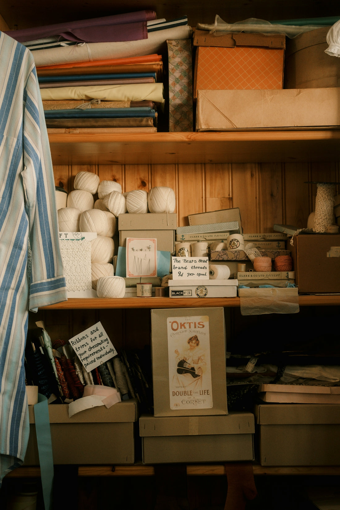 Shelves filled with fabric, boxes, and spools of thread.